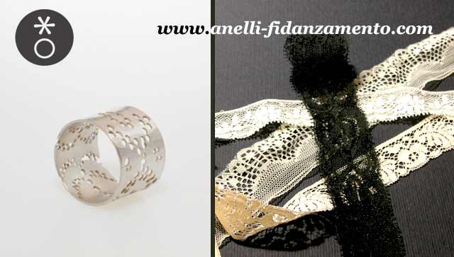 La fede nuziale in oro bianco creata da Eva sposa l'abito nei dettagli in pizzo.