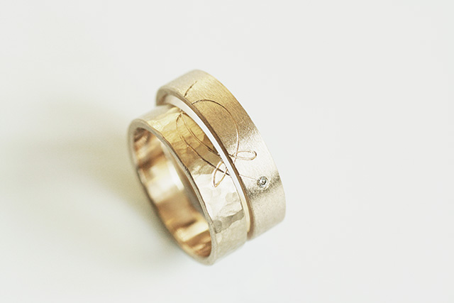 27 – Fedi “AleAle” fedi in oro bianco free nikel, una satinata e l’altra martellata, legate da un simbolo inciso a mano.