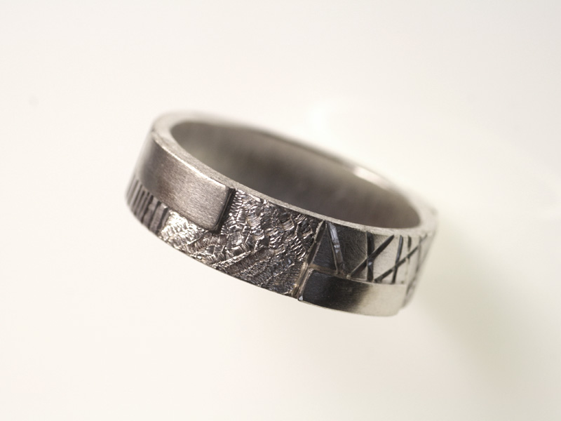 14- “Mondrian”- Fede in oro bianco incisa a mano, ripartita in più sezioni con diverse simbologie / “Mondrian” – white gold ring, engraved by hand divided in various sections with different symbols